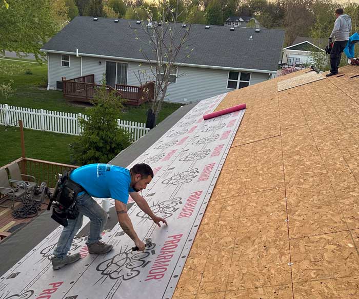 A professional roofer is installing ice and water layer on the roof near Franklin, WI