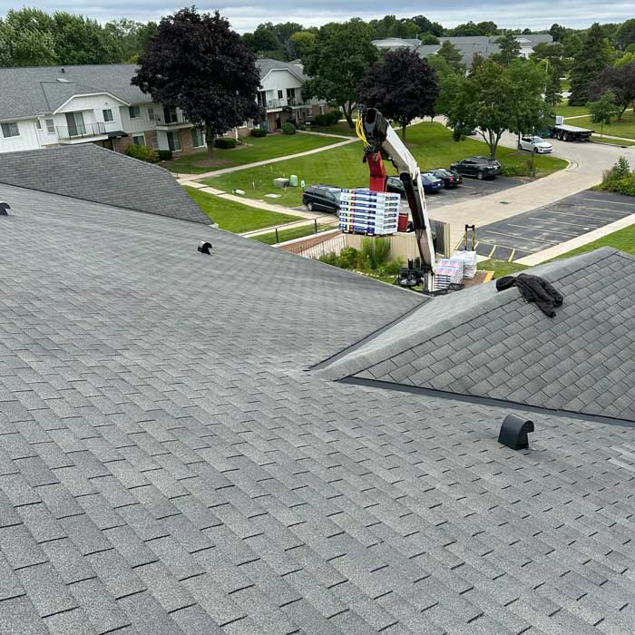 Roofers installing asphalt shingles on a home in New Berlin Wisconsin