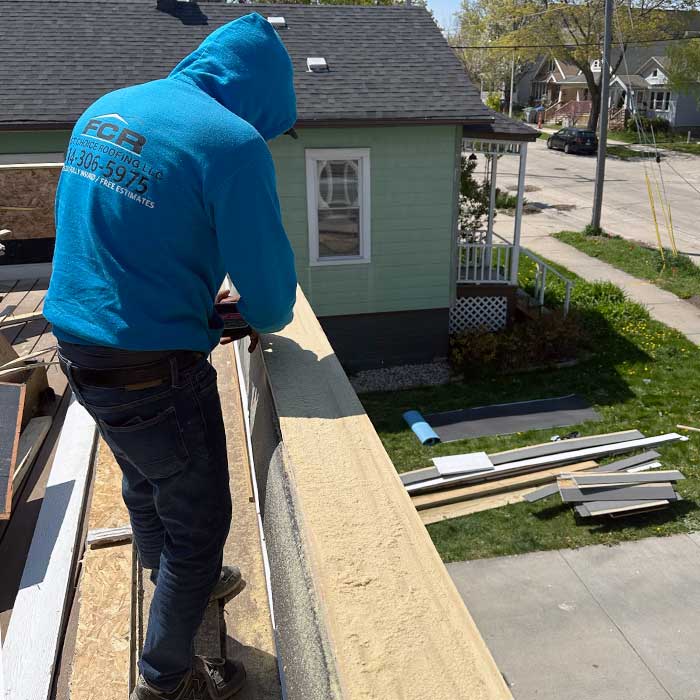 A Roofer from First Choice Roofing fixing a roof near Shorewood, Wisconsin